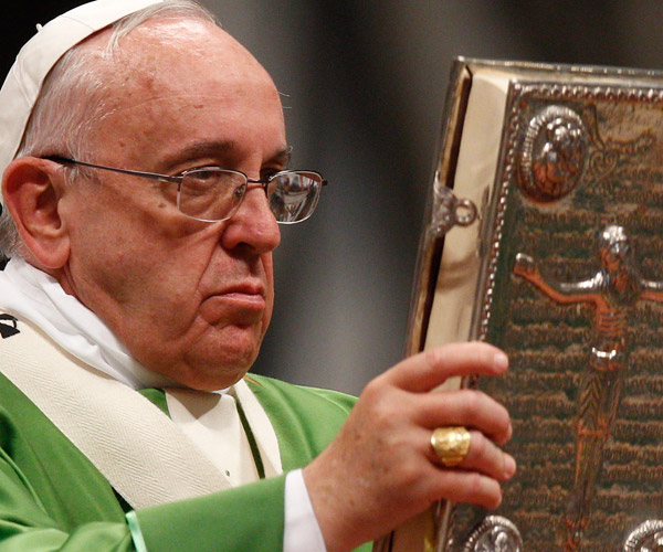 Pope Francis raises the Book of the Gospels as he celebrates a Mass to open the extraordinary Synod of Bishops on the family in St. Peter's Basilica at the Vatican Oct. 5. (CNS/Paul Haring)